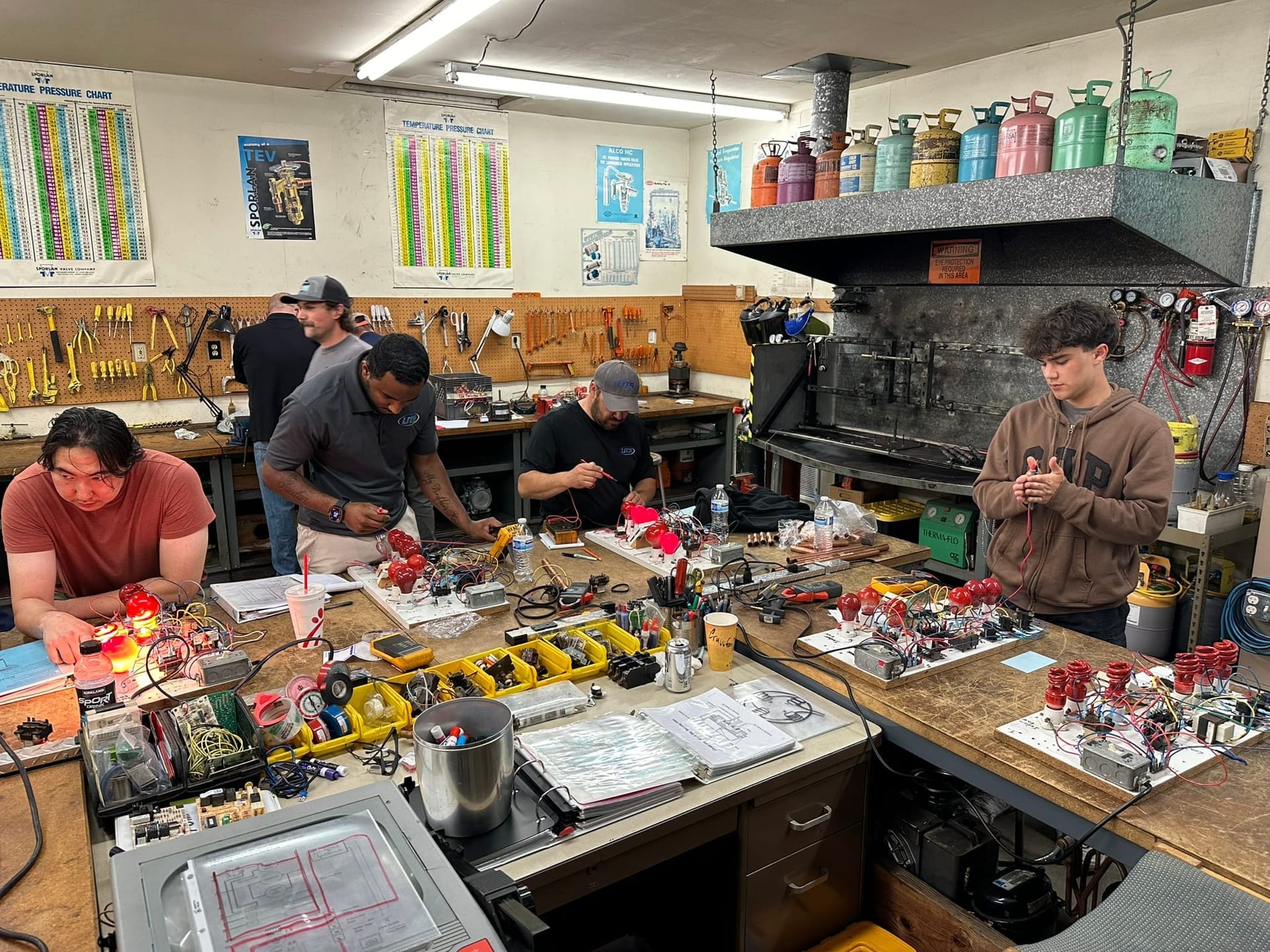 Students at benches during live lab with tools and equipment